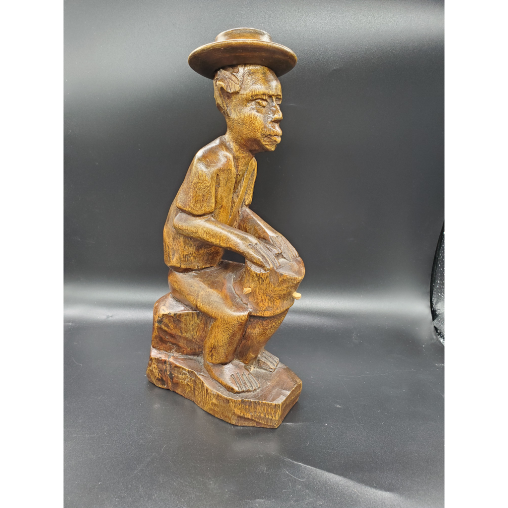 Old man playing drums, hand carved