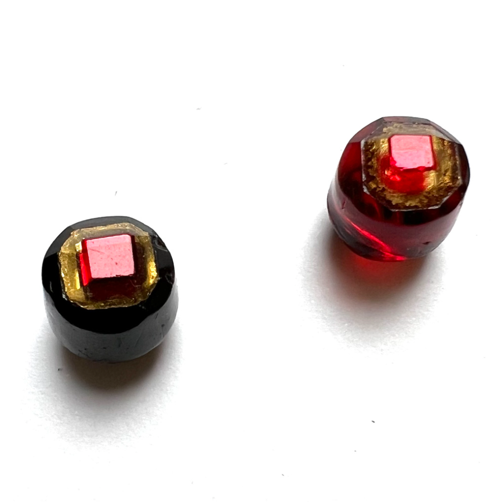 Two glass Tingue buttons in barrel shape. 